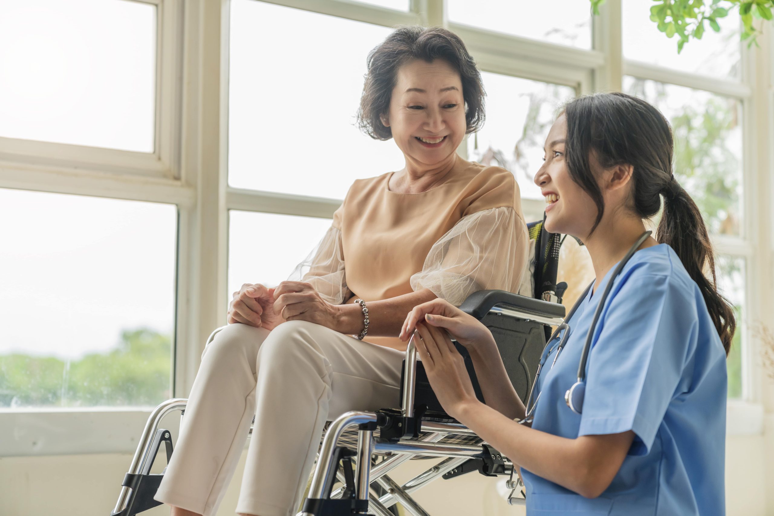 Best HMO For Seniors Plan In The Philippines Finance In A Minute   Asian Young Caregiver Caring Her Elderly Patient Senior Daycare Handicap Patient Wheelchair Hospital Talking Friendly Nurse Looking Cheerful Nurse Wheeling Senior Patient Min Scaled 